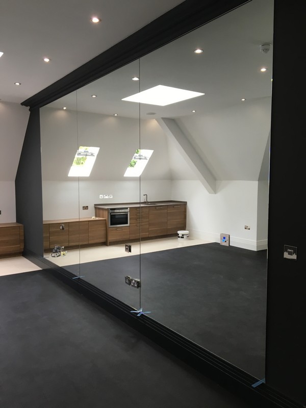 Frameless glass partition in loft conversion by Shepherd's Bush glaziers
